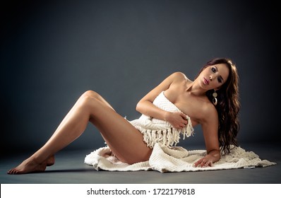 Beautiful Sensual nude woman sits covered by white cloth and hands