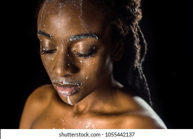 Beautiful Sensual Young African American Woman With Spilled Milk On Face Isolated On Black