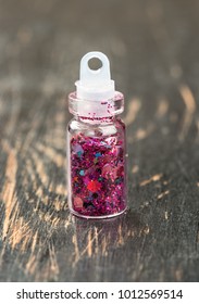 Beautiful sequins in a tiny bottle of nail design on the table