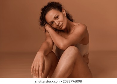 Beautiful serene middle aged woman with skin flaws and stretch marks after pregnancy and childbirth, looking confidently at camera. Self-acceptance and body love, body positive concept with copy space