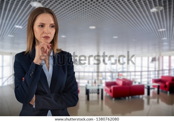 Beautiful serious business woman in dark suite\
on empty dealer center\
background