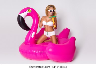 Beautiful sexy blonde model in a elegant bikini with a inflatable pink flamingo. Hit the summer. Summertime. Bikini fashion.