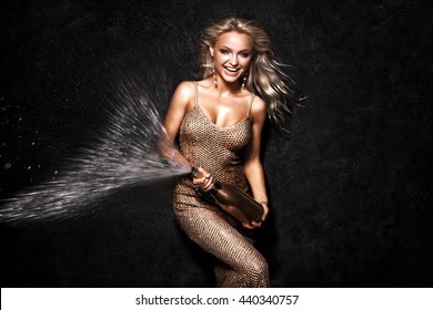 Beautiful sexy blonde woman on black background, party.