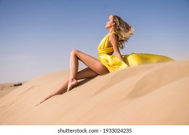 Beautiful sexy blonde  woman, walking on the top of dunes. Sahara desert. tanned skin, over blue sky, sunny day, elegant dress. love story, gold outfit,African country, white woman in desert, pretty 