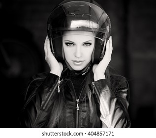 Beautiful Sexy Elegance Woman Driver, Has Happy Cool Smiling Face, Black Leather Jacket, Motorcycle Helmet, Dark Smokey Eyes. Has Slim Sport Body. Portrait Street Urban. Black And White. Quest