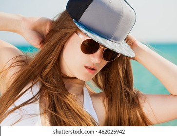 Beautiful Sexy Face Woman, Has Sunglasses, Haired Long Hair, Baseball Hat. Nature Portrait. Sea Blue Water. Close Up. Hot Beach.