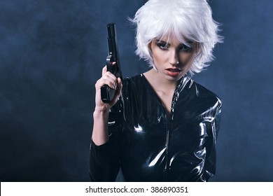 beautiful sexy girl holding gun . smoke background