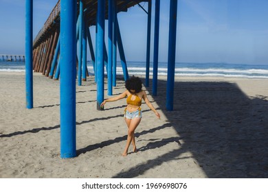 Beautiful And Sexy Mexican Woman Walking Under The Pier On The Beach In Summer