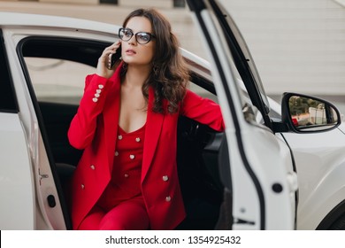 Beautiful Sexy Rich Business Woman In Red Suit Sitting In White Car, Wearing Glasses Talking On Phone, Business Lady Style