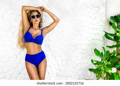 Beautiful sexy tanned woman bikini model at Maldives tropical sand beach. Young glamour girl in swimsuit near the pool. Perfect body bikini model long blonde hair. Bikini fashion. Luxury travel.