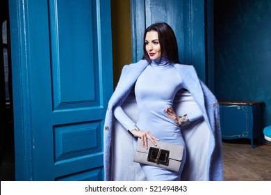 Beautiful Sexy Woman Brunette Hair Wear Fashion Clothes Business Style For Office Lady Trend Accessory Bag Casual Glamor Natural Makeup Pretty Face Interior Room Door Blue Color Coat Jacket Outwear.