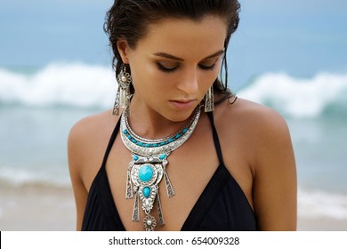 Beautiful and sexy woman on the beach wearing silver jewelry