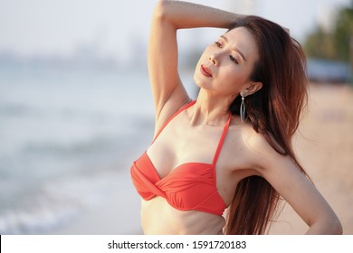 Beautiful sexy woman of perfect body in red bikini dress posing on seashore, - Shutterstock ID 1591720183