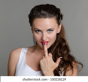 Beautiful sexy woman with red lips and showing middle finger obscene gesture