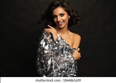Beautiful sexy woman wearing sparkle dress on black background.