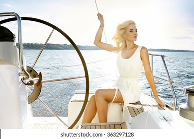 Beautiful sexy young blonde woman, riding a boat on the water, itinerary, beautiful makeup, clothing, summer, sun, perfect body figure shape tan dress swimsuit, sea marine river lake yacht 