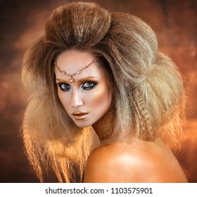 beautiful sexy young girl in gold paint in a zodiac sign of a lion