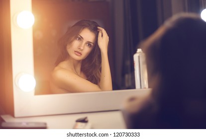 Beautiful Sexy Young Woman Looking Into A Mirror At Herself