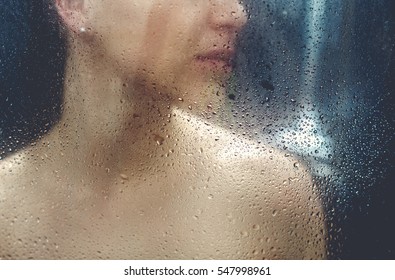 Beautiful sexy young woman washing body in a shower.
