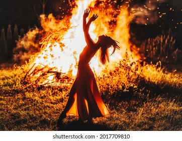 beautiful shamanic woman dancing by the fire.
