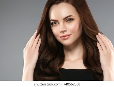 Beautiful Shine Hair Woman With Manicure Nails Hand. Brunette With Long Hair And Healthy Skin Over Gray Background.