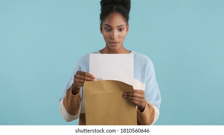 Beautiful Shocked African American Girl Opening Envelope With Exams Results On Camera Over Colorful Background