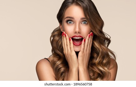 Beautiful Shocked And Surprised Woman Screaming .Beauty Female With Wavy Hairstyle. Curly Hair Girl Amazed . Expressive Facial Expressions . Red Nails Manicure.Beauty , Cosmetic And Makeup