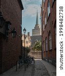 A beautiful shot of an alley of stone buildings with parked bicycles in the parking stand