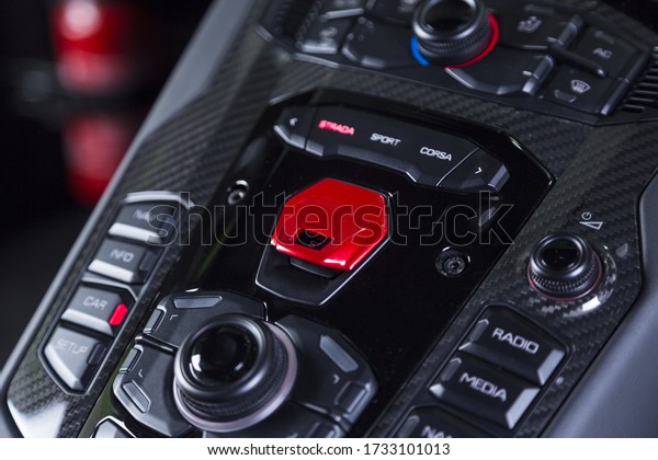 A beautiful shot of a black start engine dashboard on\
a sports car