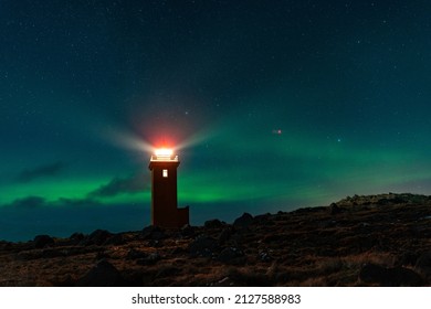 A beautiful shot of a glowing lighthouse against a starry colorful sky - Powered by Shutterstock