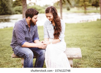 A Beautiful Shot Of A Happy Couple Holding Hands While Praying With A Blurred Background