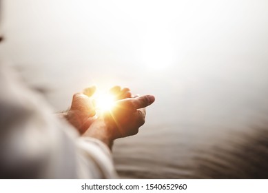 A beautiful shot of Jesus Christ holding hope and light in his palms with a blurred background