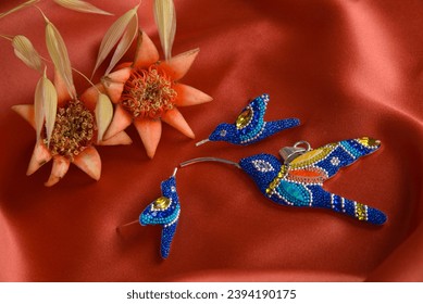 beautiful silver blue hummingbirds with orange fabric background and very cute flowers - Shutterstock ID 2394190175