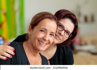 beautiful sister in law holding each other smiling in the kitchen