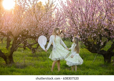 Beautiful sisters in amazing dresses in the gardens - Shutterstock ID 638307520