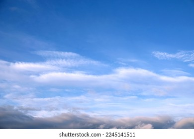 Beautiful sky landscape with light white clouds high in the stratosphere and layer of dark clouds at low on a sunny day - Shutterstock ID 2245141511