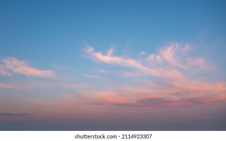A beautiful sky painted by the sun leaving vibrant gold and pink hues. Clouds in the twilight sky, in the evening. Image of a cloudy sky in the evening. Evening sky scene with golden light 