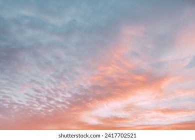A beautiful sky tinted by the sun leaving vibrant shades of gold, pink, blue and multicolored. Clouds in the twilight evening and morning sky. Cloudy sky background in the evening, and during the day.