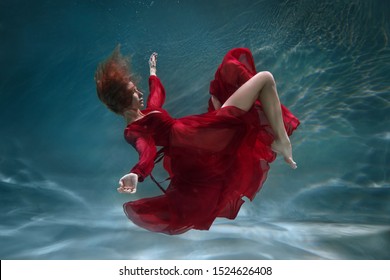 Beautiful slender girl in a long red dress underwater. - Powered by Shutterstock