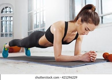 Beautiful slim brunette  doing some push ups a the gym