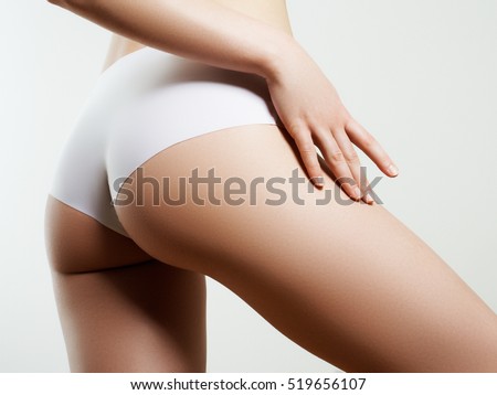 Beautiful slim woman's body. Perfect slim toned young body of the girl. Fitness or plastic surgery and aesthetic cosmetology. Taut elastic ass. Firm buttocks