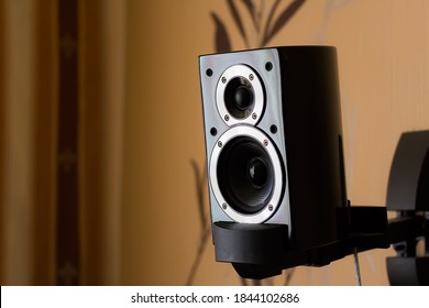 A Beautiful Small Bookshelf Loudspeaker In Black Piano Lacquer On The Bracket In The Living Room