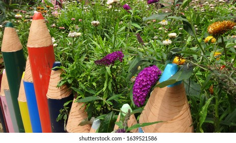 A Beautiful Small Garden With A Fence Made To Look Like A Large Colorful Pencil