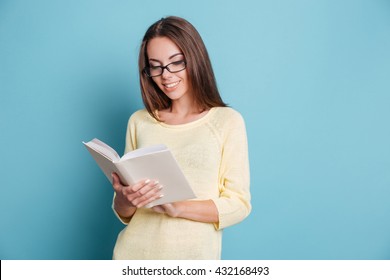 Beautiful Smart Young Girl Reading Book Isolated On The Blue Background