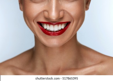 Beautiful Smile With Healthy White Teeth And Red Lips. Closeup Of Smiling Woman Mouth With Plump Full Lips With Perfect Red Lipstick Makeup. Teeth Whitening, Dental Health Concepts. High Resolution