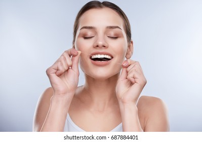 Beautiful Smile, White Strong Teeth. Head And Shoulders Of Woman With Snow-white Smile Holding Tooth Thread, Stomatological Concept. Girl Cleaning Tooth With Thread, Closed Eyes