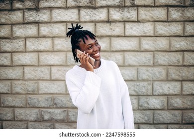 Beautiful smiling african woman talking by mobile phone against brick wall background. - Powered by Shutterstock