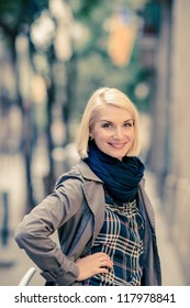 Beautiful smiling blond woman wearing blue scarf outdoors