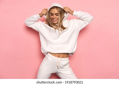 Beautiful smiling blonde woman wear of white set of track suit isolated on pastel background