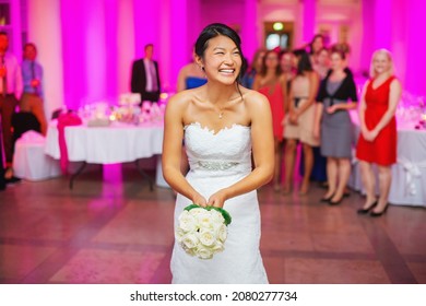 a beautiful, smiling bride at the wedding is ready to throw the bridal bouquet